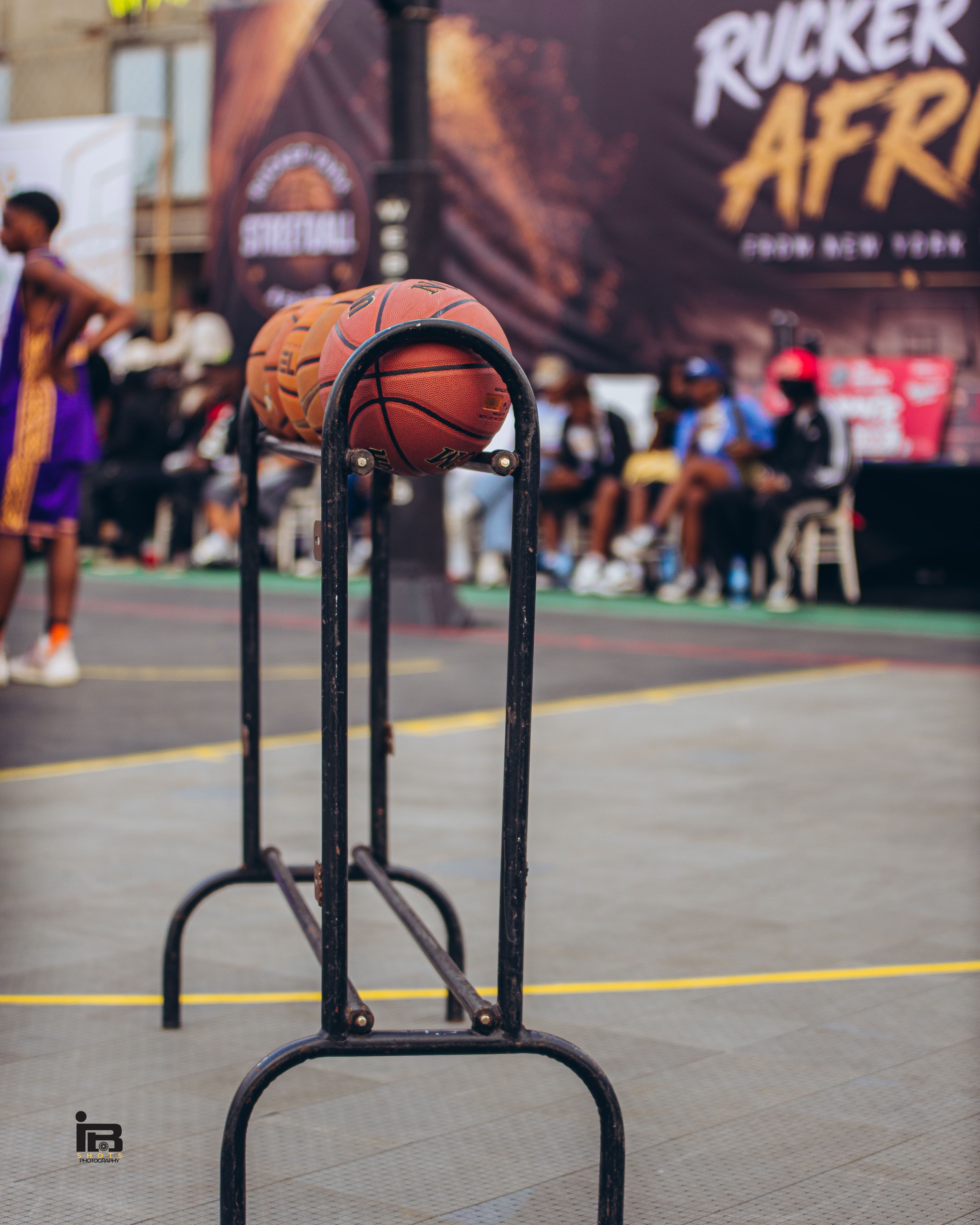 E.J. Anosike on court with young participants and the crowd behind him at Rowe Park, Lagos